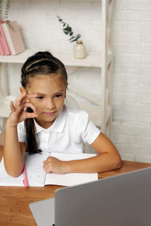 happy little child girl using laptop computer for studying online e-learning system. online lesson...