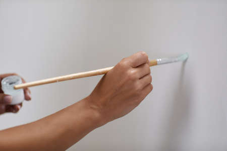 female hand of artist with brush painting on canvasの写真素材