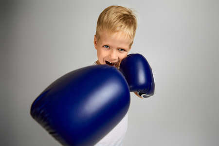 little boxing fighter boy in blue boxer gloves fightingの写真素材