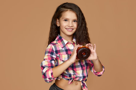 attractive little child girl holding yummy chocolate donutの写真素材