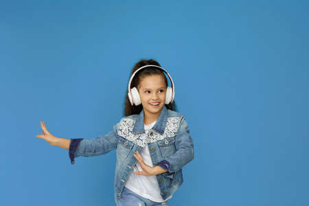 little child girl in white headphones dancingの写真素材
