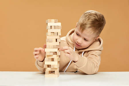children plays with wooden constructor on desk.の写真素材