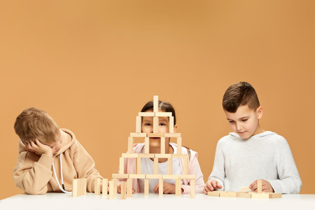 children plays with wooden constructor on desk.の写真素材