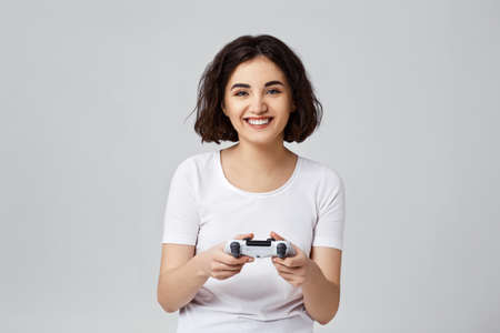 girl playing video games on gray backgroundの写真素材