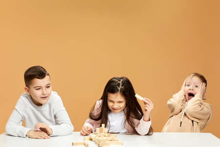 children plays with wooden constructor on desk.の写真素材