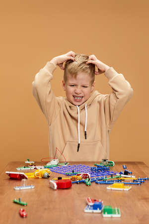 child boy playing with electronic constructor on desk.の写真素材