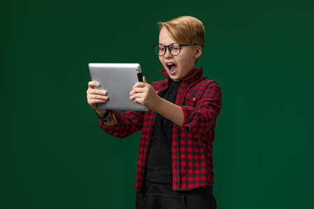 child boy in red checkered shirt using digital tabletの写真素材