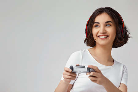 girl playing video games on gray backgroundの写真素材
