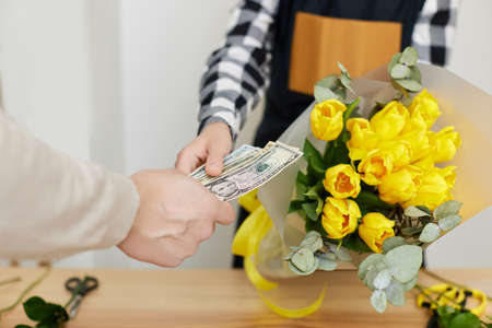 Woman florist selling flowers to a manの写真素材