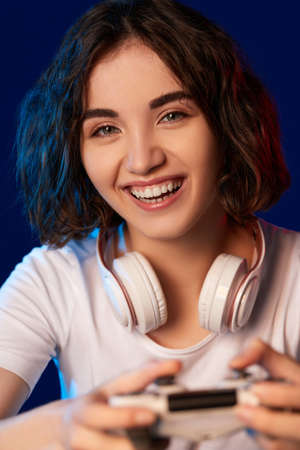 happy curly involved gamer girl playing video gamesの写真素材