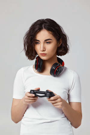 girl playing video games on gray backgroundの写真素材