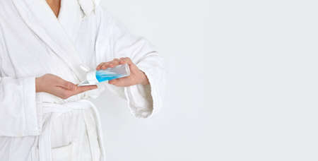 female hands hold a cotton swab and tonic to remove makeup.