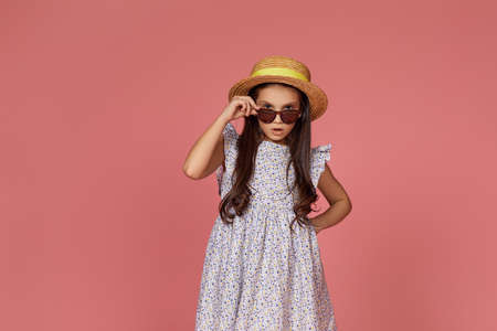 cute little child girl in summer dress, hat and sunglasses