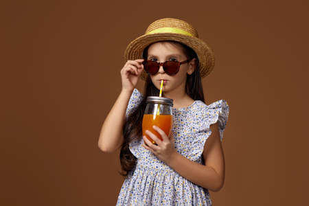 cute little girl in hat with orange juiceの写真素材