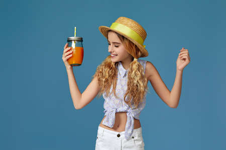 Portrait of cute little child girl drinking orange juice