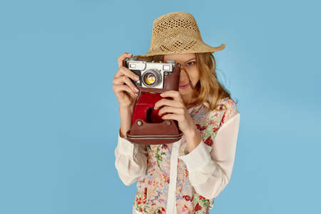 curly blonde woman holding retro vintage photo camera,の写真素材