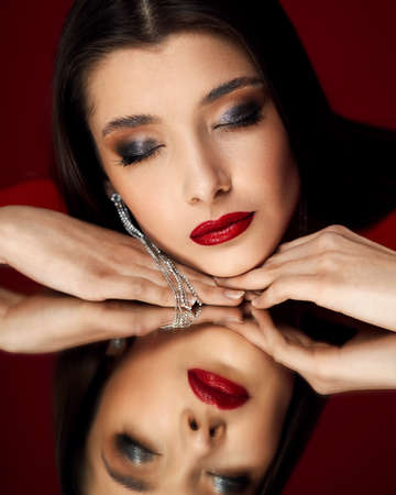 brunette woman with long hair and bright make-upの写真素材