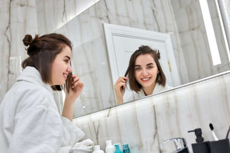 beautiful smiling woman in front of mirrorの写真素材