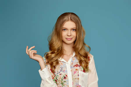 young curly blonde woman pointing to the side