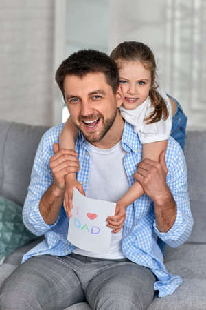 daughter congratulates her father and gives him postcard.の写真素材