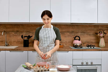 Young beautiful housewife cooking on kitchen at home.の写真素材