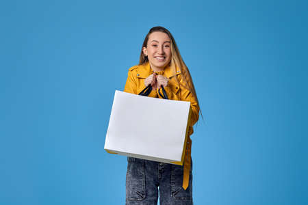 woman in leather jacket holding shopping bag with purchases