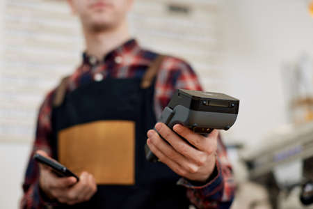 barista in apron hold modern bank payment terminalの写真素材