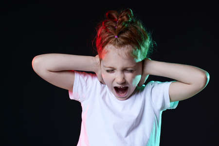 redhead little child girl screaming on black background.の写真素材