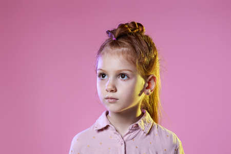 cute redhead little child girl on pink background.の写真素材