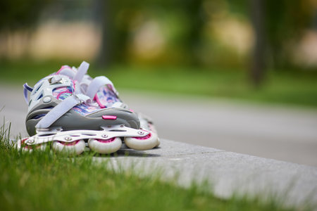 Pair of stylish roller skates on nature background