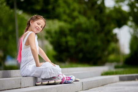 cute little girl on roller skates at park.の写真素材