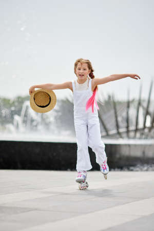 Cute little child girl on roller skates at parkの写真素材
