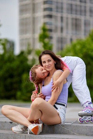 little girl on roller skates and her mother in park.の写真素材