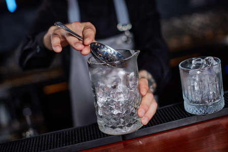 Professional male bartender makes an alcoholic cocktail