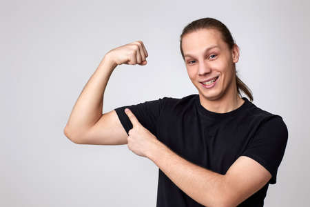 young fitness strong man show biceps muscles on handの写真素材