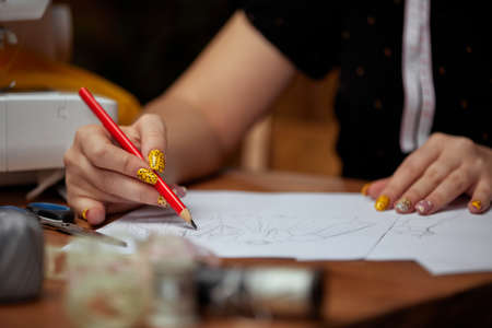 Fashion designer drawings with a pencil sketchesの写真素材