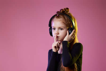 child girl in sunglasses and headphones listening to musicの写真素材
