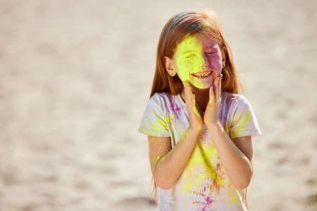 Portrait of happy little child girl in holly paints