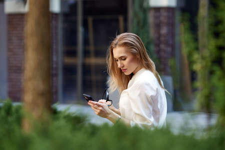 beautiful blonde business woman using the smartphoneの写真素材