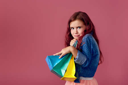 little caucasian child girl holds shopping bagsの写真素材