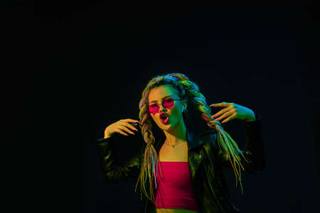 young woman with dreadlocks in red sunglasses dancingの写真素材