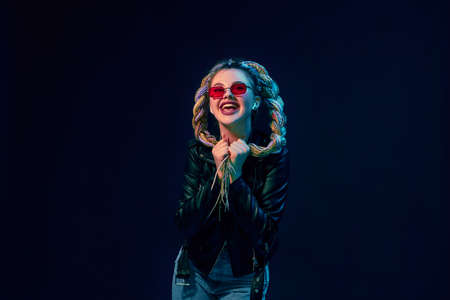 young woman with dreadlocks in red sunglasses dancing