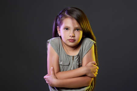 Unhappy little child girl feel cold on dark backgroundの写真素材