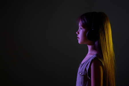 cute child girl in wireless headphones listening to musicの写真素材
