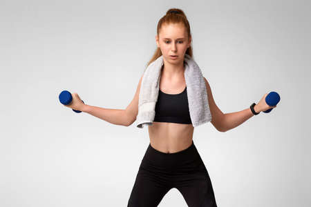 woman in black sportswear working out with dumbbellsの写真素材