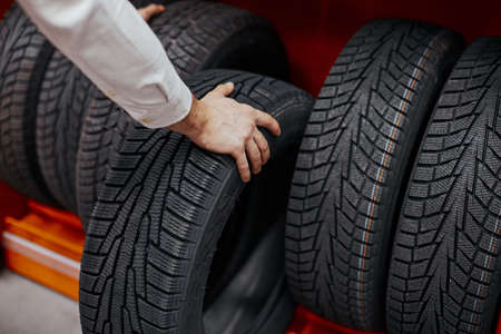 close-up of a mans hand with car tires