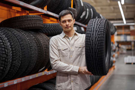 male customer taking new tires in the supermarket.