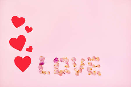 Word love made of pink rose petals on pink background.の写真素材
