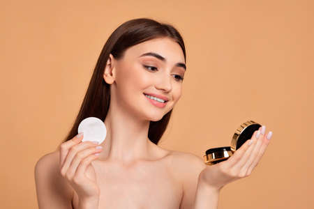 woman look at mirror and holding white cotton pad