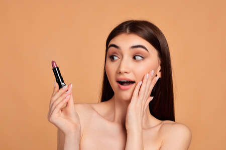 young happy positive woman holding pink lipstickの写真素材